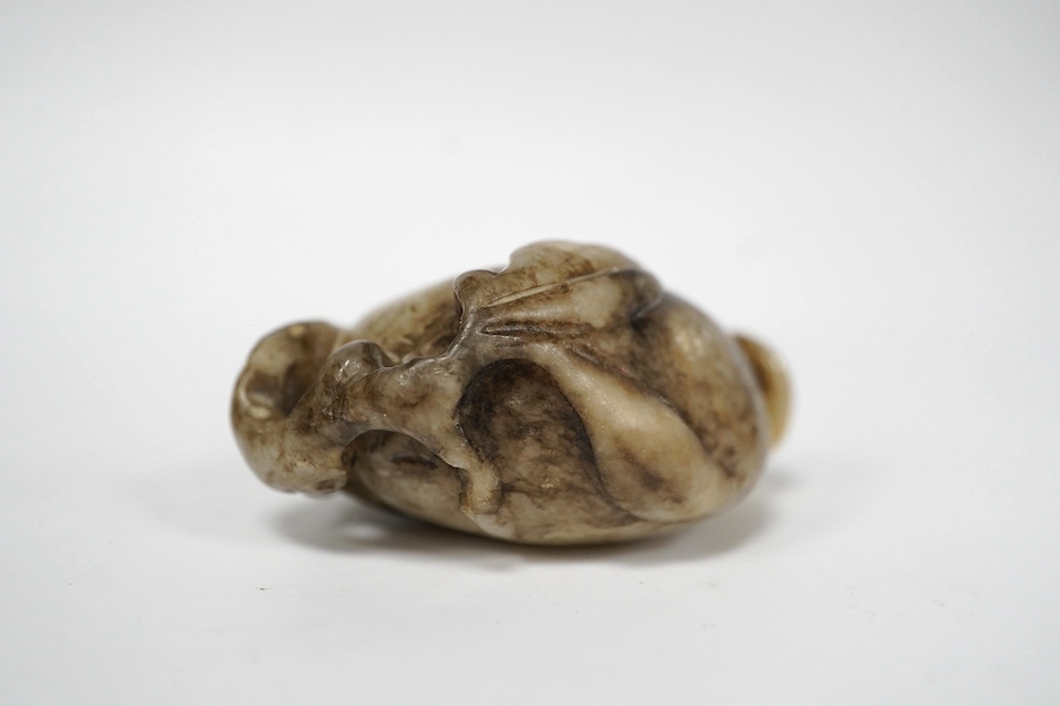 A Chinese white and black jade pendant now hollowed as a snuff bottle, and a Chinese celadon jade figure of a buffalo. Condition - fair to good